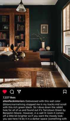 an open book on a table in a room with dark green walls and wooden furniture