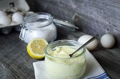 a glass jar filled with yogurt sitting on top of a table next to an egg