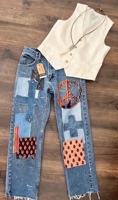 an old pair of jeans with patchwork on them and a white t - shirt