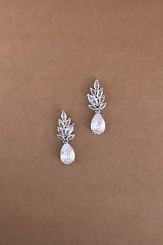 two pairs of earrings on a brown background