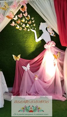 the backdrop is decorated with pink and white flowers, butterflies, and paper cut outs