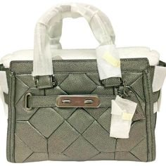 NEW WITH TAGS AND IN ORIGINAL PACKAGING! COACH Metallic Patchwork Swagger 27 Leather Bag Style: 34547 Color: Gunmetal Retail Price: $550.00   Metallic patchwork (quilted look) leather Inside zip, cell phone and multifunction pockets Zip-top closure, fabric lining Feet Dark gunmetal hardware Handles with 4" drop Longer strap with 19" drop for shoulder wear Approx. Measurements: 10 3/4" (L) x 7 3/4" (H) x 5 3/4" (W) Come with dust bag Please check out my store for many more fabulous finds "Foxwood Quilted Leather Satchel Bags, Coach Quilted Leather Bag, Coach Textured Leather Rectangular Satchel, Coach Rectangular Textured Leather Satchel, Luxury Coach Textured Leather Satchel, Designer Quilted Satchel Shoulder Bag, Luxury Quilted Leather Satchel, Luxury Quilted Coach Bag, Gunmetal Hardware