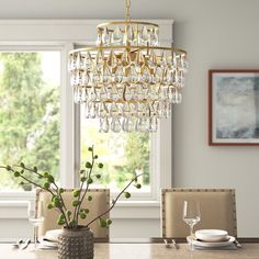 a chandelier hanging from the ceiling in a dining room with white walls and windows