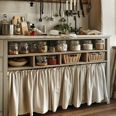 a kitchen with lots of utensils hanging from the wall and on the counter