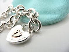 Offered for sale is a wonderful and super pretty Tiffany and Co. Sterling Silver 18K Gold Heart Key Hole Charm bracelet. The piece is made from substantial and bright Tiffany silver, and yet retains a very feminine feel to it. Attached to its very substantial and bright Tiffany Silver charm bracelet is a super pretty Heart Key Hole charm! The Heart charm has a Tiffany & Co circle clasp that opens and closes, and thus can be used as a charm on a necklace or as part of another charm bracelet! Supe Rare Gifts, Heart Key, Heart And Key, Bracelet Chain, Gift Love, Silver Charm Bracelet, Tiffany And Co, Key Hole, Tiffany Heart