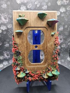 🌿✨ **Transform Your Home with Nature-Inspired Outlet Covers ✨🌿 Looking to bring a touch of magic and whimsy into your space? Check out these handmade **moss-covered wooden outlet covers each uniquely designed with: 🍄 **3D-printed mushrooms**   🐌 **Adorable snails**   💎 **Real crystals** for a mystical vibe! Perfect for fairy garden lovers or anyone wanting to bring a little forest charm into their home. Each cover is lovingly crafted to create a one-of-a-kind piece that blends nature with p Cool Outlet Covers, Diy Outlet Covers Ideas, Outlet Covers Ideas, Wooden Outlet Covers, Diy Outlet Covers, Healing Decor, Light Switch Art, Wall Outlet Covers, Mushroom Core