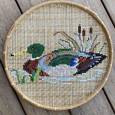 a cross stitch picture of a duck in the water