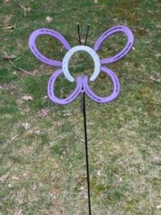 a purple butterfly stake in the grass