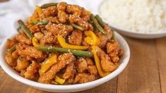 a white bowl filled with meat and vegetables next to rice