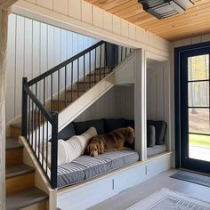 a dog laying on top of a bed under a stair case