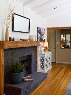 an image of a living room with fireplace and pictures on the wall in front of it