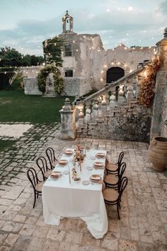 an outdoor dining area with tables and chairs set up in front of a stone building