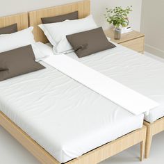 the bed has two pillows on it and is made up with white sheets, brown pillowcases