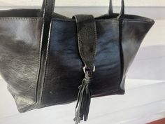 "Handbag Claudia Firenze black leather tote 11 1/2\" L 15 1/2\" L lying flat 9 1/2\" H 4:d 10 1/2\" shoulder drop zip closure at top and tab fold over with snap and tassel on end black fabric lining and one internal zip pocket Made in Italy Bag is in excellent condition" Fall Black Leather Lined Shoulder Bag, Black Leather-lined Bags For Fall, Fall Black Bags With Leather Lining, Black Leather Lined Bags For Fall, Medium Black Satchel For Everyday Use, Medium Leather Shoulder Bag For Errands, Green Leather Handbag, Black Leather Tote, Leather Handbags Tote