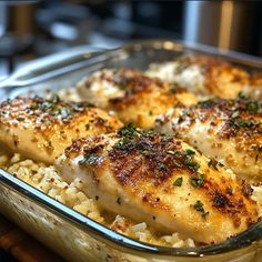 chicken and rice casserole with parsley in a glass dish on a wooden table