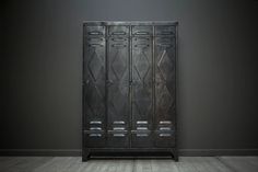 an old metal locker in a room with wood flooring and walls painted dark grey