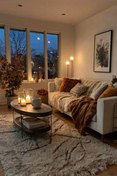 a living room filled with lots of furniture and candles on top of the coffee table