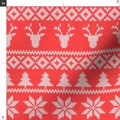 a red and white knitted fabric with snowflakes, deers and trees on it