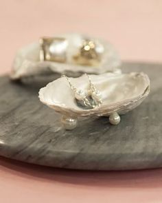 an oyster shell with pearls on it and a necklace in the middle is sitting on a table