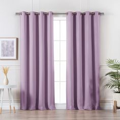 a living room with purple curtains and a potted plant