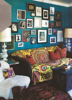 a living room with blue walls and pictures on the wall above it's couch