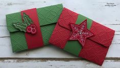 two christmas cards with red, green and white designs on them sitting next to each other