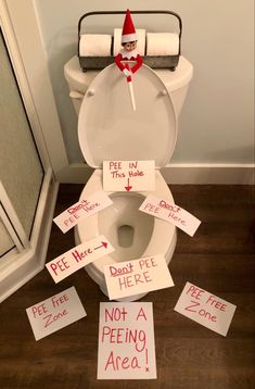 a toilet that has been decorated with signs on the lid and in front of it