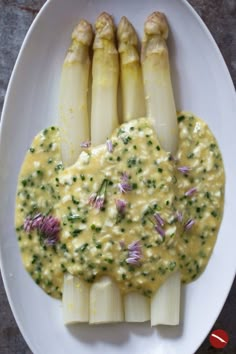 asparagus with cheese sauce on a white plate