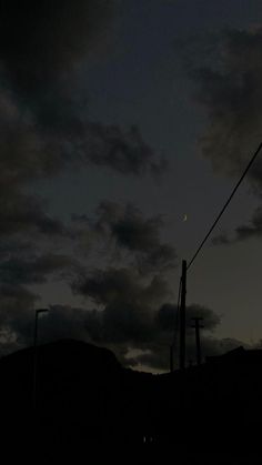 the night sky is dark and cloudy, with some clouds in the distance as well