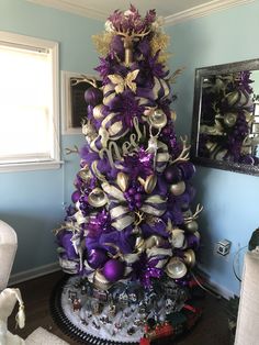 a decorated christmas tree with purple and gold ornaments