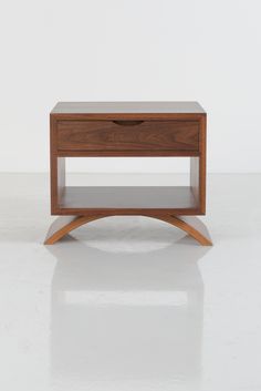 a small wooden table with two drawers on one side and an open drawer on the other