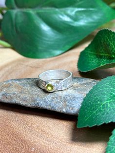 A handcrafted Silver ring adorning a beautiful peridot gemstone!  This is crafted with metal clay, a medium that when heated turns to 999 solid silver! Natural oxidation can occur Ring is a size 5 Peridot is a powerful cleanser.  It releases and neutralises toxins on all levels.  Alleviates jealousy, resentment, spite, bitterness, irritation, hatred and greed.  Reduces stress, anger and guilt.  Peridot opens our hearts to joy and new relationships.  It enhances confidence and assertion, motivati Handmade Green Birthstone Promise Ring, Handmade Green May Birthstone Ring, Handmade Birthstone Ring For Anniversary, Green Citrine Jewelry For Anniversary, Yellow Jewelry For May Birthstone, Yellow Birthstone Jewelry For May, Handmade Green Birthstone Ring For Anniversary, Citrine Birthstone Jewelry, May Birthstone Jewelry With Stone Setting