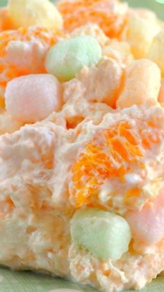 an orange and white dessert with marshmallows in it on a green plate