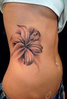 a woman's stomach with a flower tattoo on it