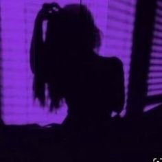 the shadow of a woman's head is shown in front of a purple background