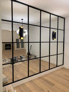 an empty room with a large mirror on the wall and hard wood flooring in front of it