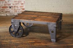 a table made out of metal and wood with wheels