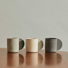 three cups sitting on top of a wooden table