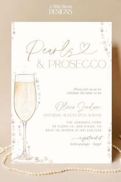 a white card with pearls and champagne on the front, reads pearls & proscicoo