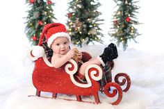 a baby sitting in a sleigh with christmas decorations