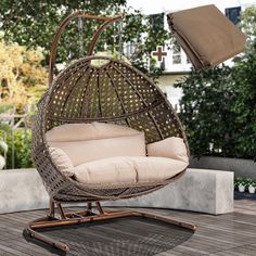 an outdoor swing chair with pillows on it