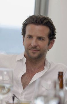 a man sitting at a table with wine glasses