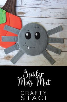 a spider made out of construction paper on top of a white wooden surface with the words spider