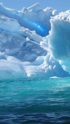 an iceberg floating in the ocean with blue water