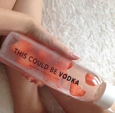 a woman is holding a bottle with strawberries in it that says, this could be vodka