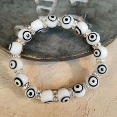 Handmade White Black Turkish Evil Eye Glass Egyptian Crystal Talisman Bracelet Features 10mm Diameter Turkish Evil Eye Glass Beads With Black And White "Eye" Features 7mm Egyptian Crystal Rondelles With Silver Plating Each Bracelet (And Each Glass Bead!) Is Unique And Just A Bit Different Due To Its Handcrafted Nature Average Inside Measurement Is 6.5" Unstretched The Evil "Eye" On These Beads Is Believed In Many Parts Of The World To Be A Talisman That Helps Ward Off Evil Pd 0075 Tory Burch Bracelet, Brighton Bracelets, Turkish Evil Eye, Circle Bracelet, Eye Glass, Coral And Gold, Onyx Bracelet, Cross Bracelet, Silver Bangle Bracelets