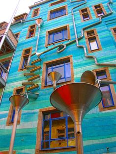 a tall blue building with lots of windows next to a street light and fire hydrant