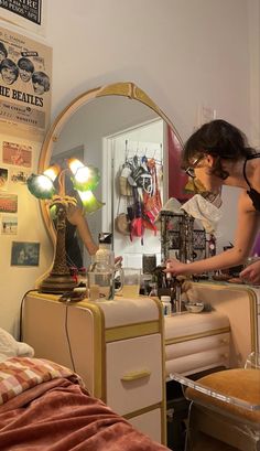 two women are standing in front of a mirror and looking at the lights on her dresser