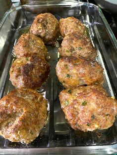 some meat patties are cooking in a pan