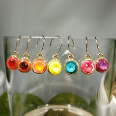 "Choose from one of 7 designs: One of a kind clay (red with scarlet, red with fire opal, yellow with sunshine, turquoise with laguna delite, purple with burgundy, orange with orange glow and cherry vanilla blend with royal red delite) and resin (creates a glass like finish) dangling earrings. Embellished with an embedded austrian crystal (6.2mm chatons) in a 15x11mm gold plated pewter bezel. Approximate length 1\". Hung on gold filled end ball ear wires. Photos taken in studio light.  Free U.S. Colorful Hypoallergenic Dangle Jewelry, Vibrant Colorful Earrings For Gifts, Colorful Round Earrings Gift, Colorful Round Earrings For Gift, Colorful Round Jewelry For Gifts, Red Jewelry With Matching Earrings For Everyday, Modern Handmade Rainbow Jewelry, Vibrant Drop Earrings Jewelry Gift, Rainbow Drop Earrings As A Gift